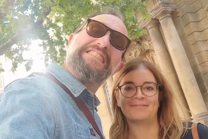 Couple selfie under trees by historic Aix-en-Provence architecture during a self-guided scavenger hunt tour