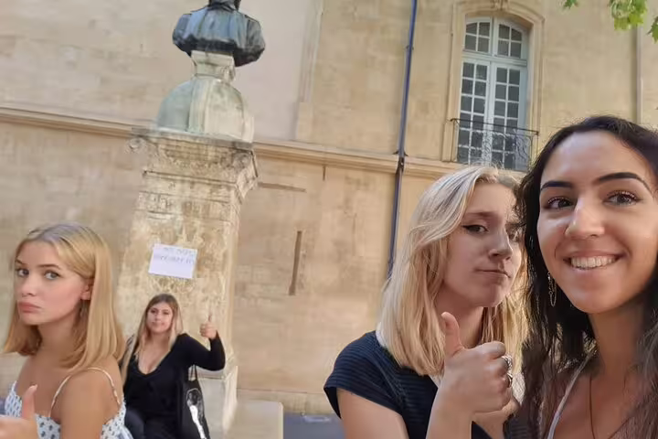 Travelers smiling by Aix-en-Provence fountain and old town on a self-guided scavenger hunt walking tour