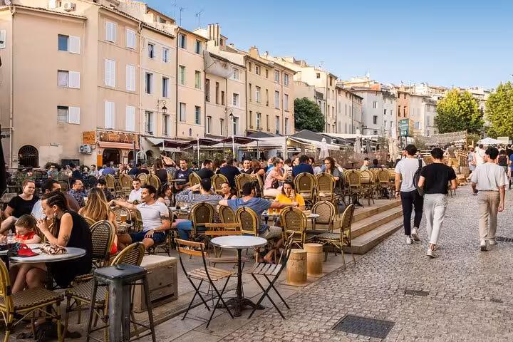 Vibrant outdoor café scene in Aix-en-Provence with visitors enjoying al fresco dining in the bustling city square.
