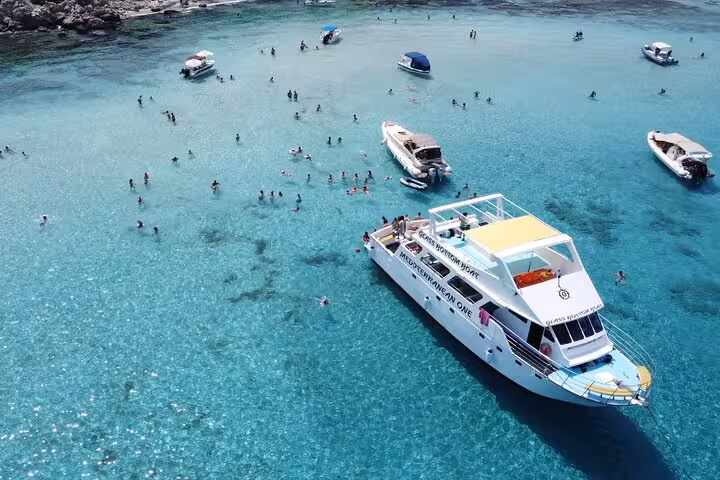 Akamas Blue Lagoon boat trip from Paphos, catamaran anchored in shallow clear water with snorkelers