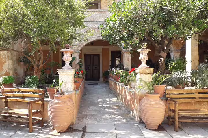 Charming courtyard with lush greenery and traditional architecture on the Akrotiri Peninsula hiking tour.