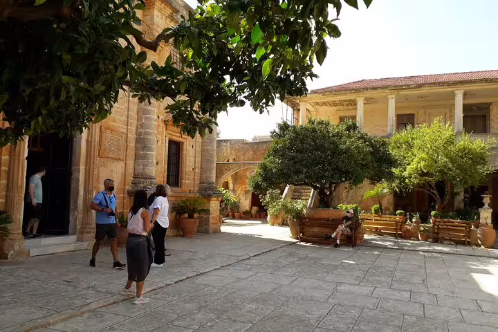 Visitors admire the serene courtyard of a historic site on the Akrotiri Peninsula hiking tour.