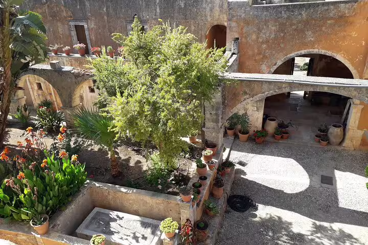Lush courtyard garden with stone pathways at a historic site on Akrotiri Peninsula, featured in private hiking tours.