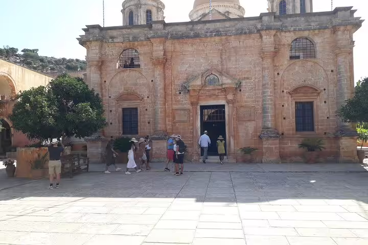 Tourists gather at an impressive stone facade on the Akrotiri Peninsula private hiking tour.