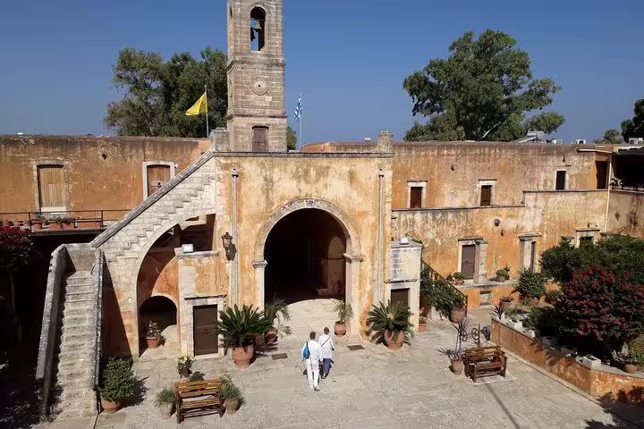 Tourists entering historic monastery gate on Akrotiri Peninsula, ideal for half-day private hiking tour exploration.