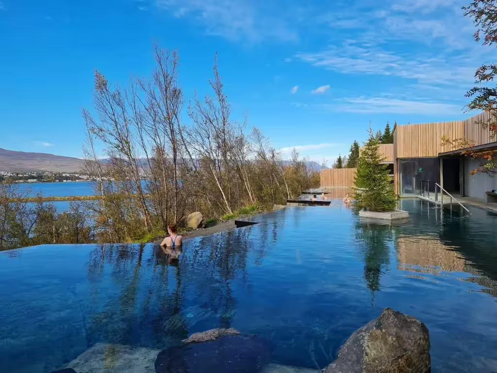 Geothermal infinity pool overlooking fjord near Akureyri Iceland with bathers enjoying warm waters
