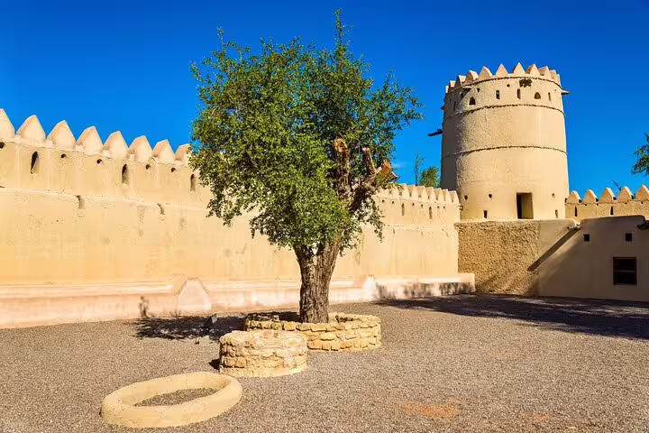 Historic fortress with iconic tower and tree in Al Ain, offering a glimpse into the UAE's rich heritage.