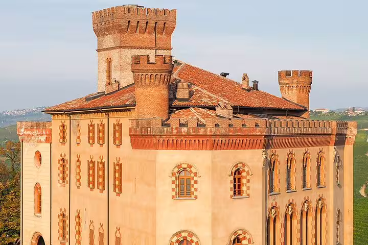 Close-up of a historic castle in Alba, showcasing architectural elegance amidst lush vineyard landscapes.