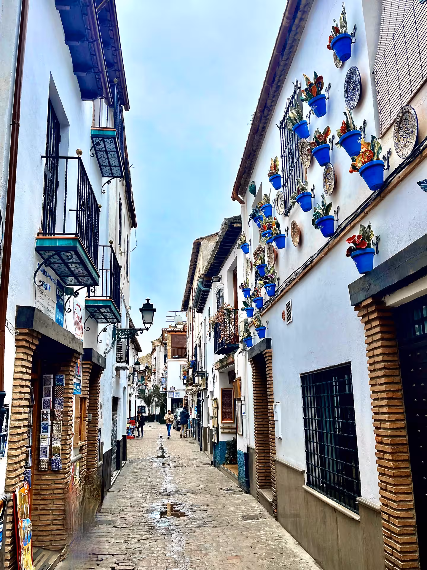 Albaicín Granada whitewashed street with blue flower pots, a highlight of Encantos Locales + Alhambra tour
