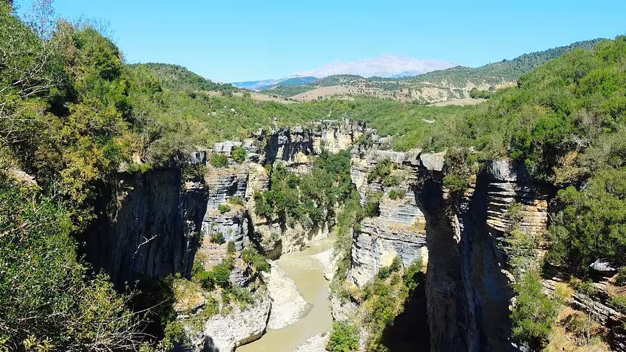 Stunning view of the Osum Canyon in Albania, showcasing dramatic cliffs and a winding river under a clear blue sky.