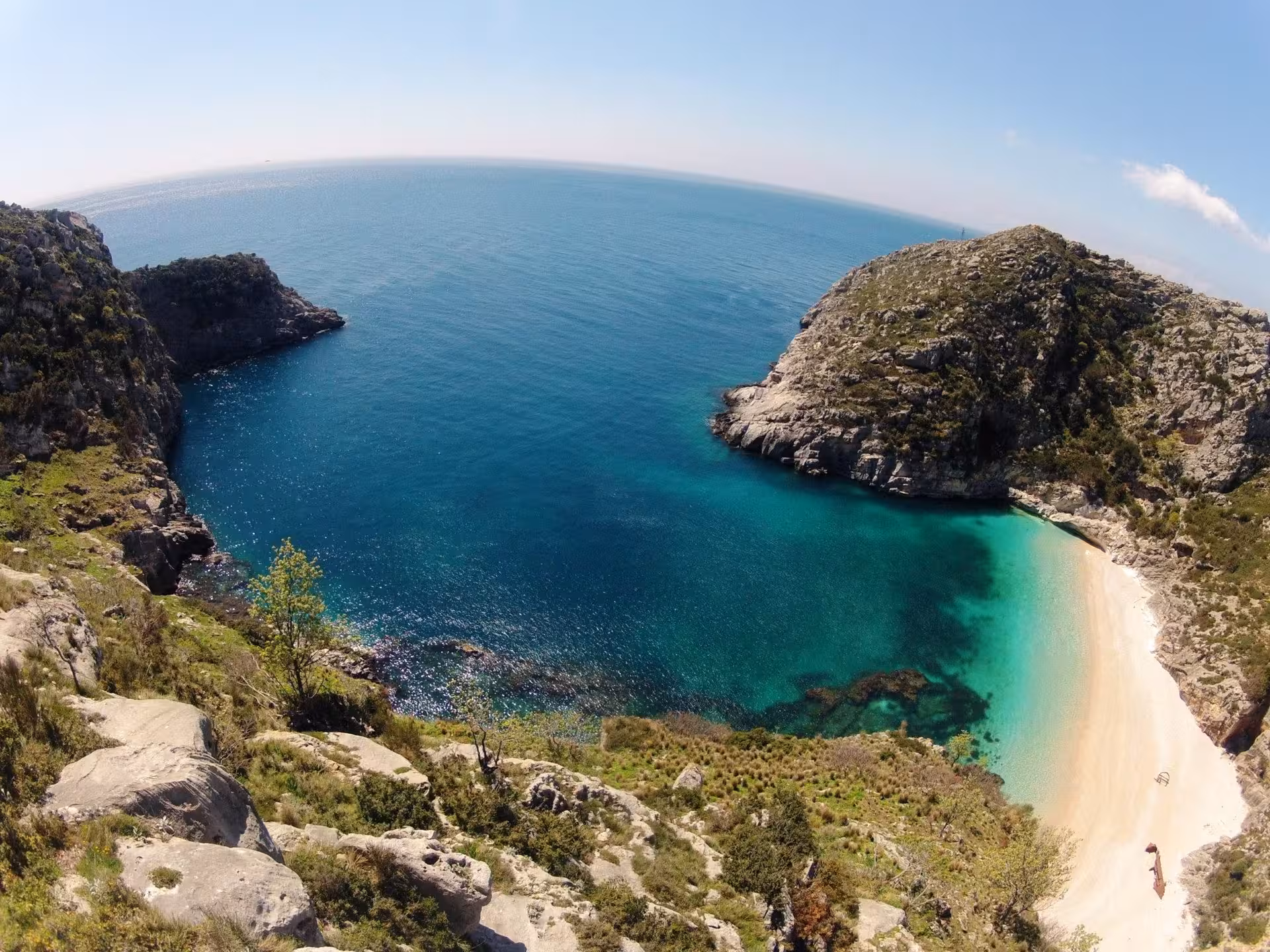 Pristine beach with turquoise waters and rocky cliffs in Albania, perfect for kayaking and coastal exploration.
