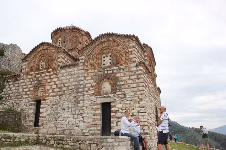 Travelers visit the ancient Byzantine church in Berat, Albania, highlighting the country's historical and architectural marvels.