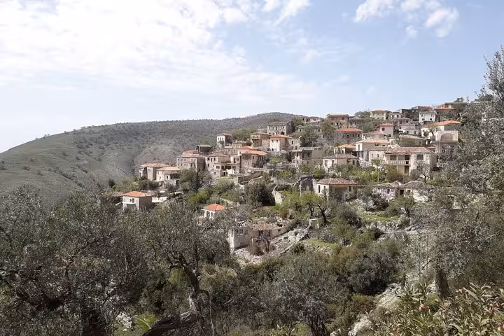 Scenic view of a traditional Albanian hillside village with stone houses, offering a glimpse into rural life and culture.