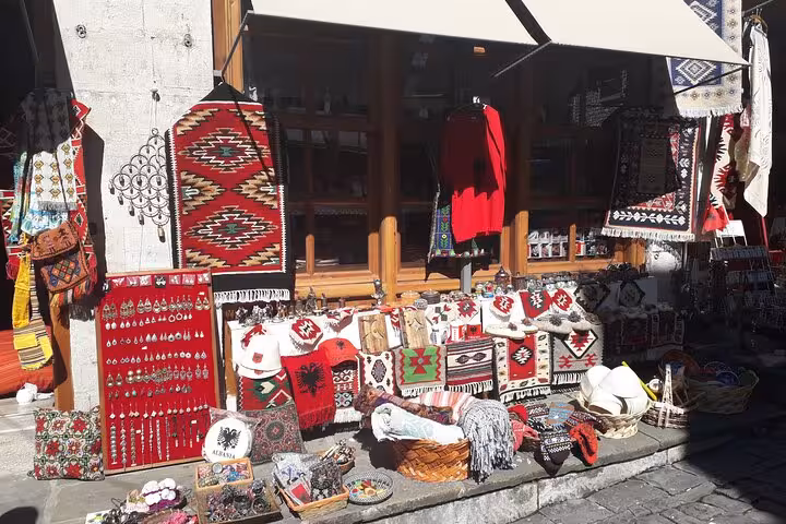 Colorful display of traditional Albanian textiles and crafts at a market, showcasing cultural highlights on a 6-day tour.