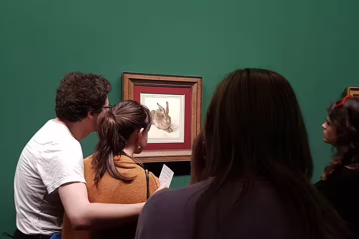 Visitors admiring Albrecht Dürer's 'Young Hare' drawing at Albertina Museum, highlighting intricate details on a private tour.
