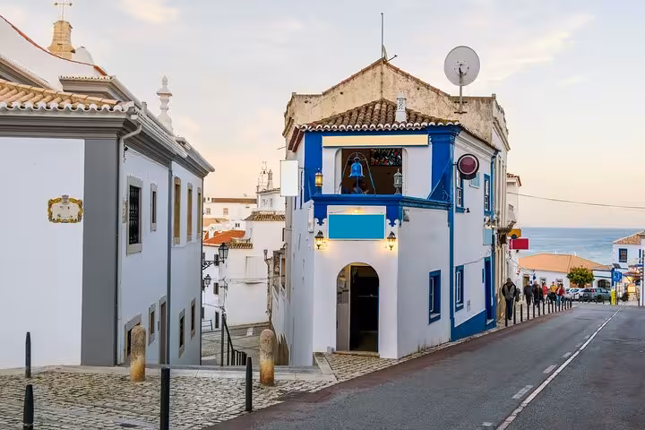 Charming narrow street in Albufeira with traditional architecture and ocean views, ideal for a guided city walk tour.