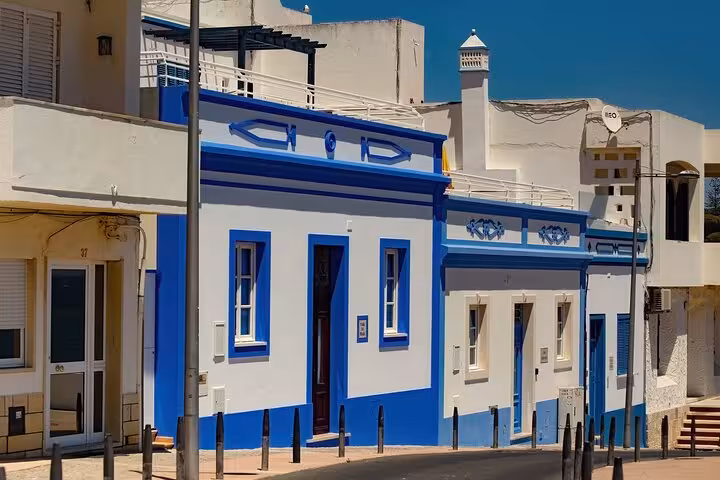 Charming street in Albufeira featuring traditional white and blue Portuguese architecture on a sunny day.