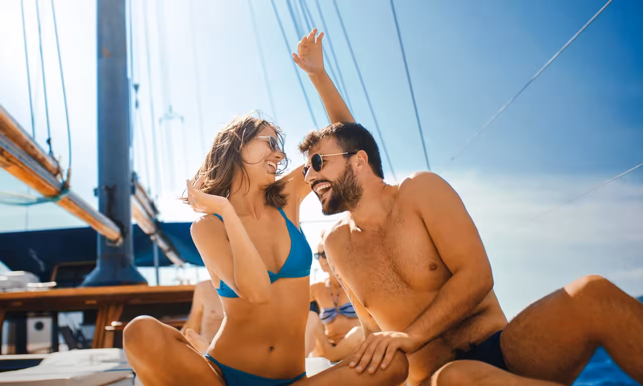Happy couple laughing on a private sunset cruise sailboat in Albufeira enjoying a romantic Algarve experience