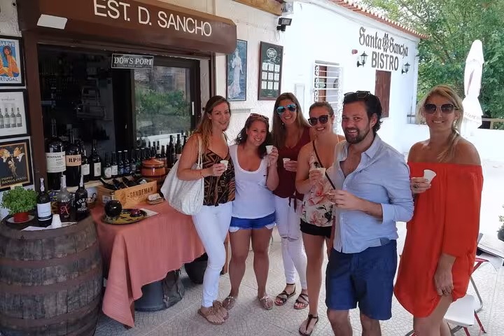 Group enjoying wine tasting at a rustic Algarve winery during a full-day tour from Albufeira.