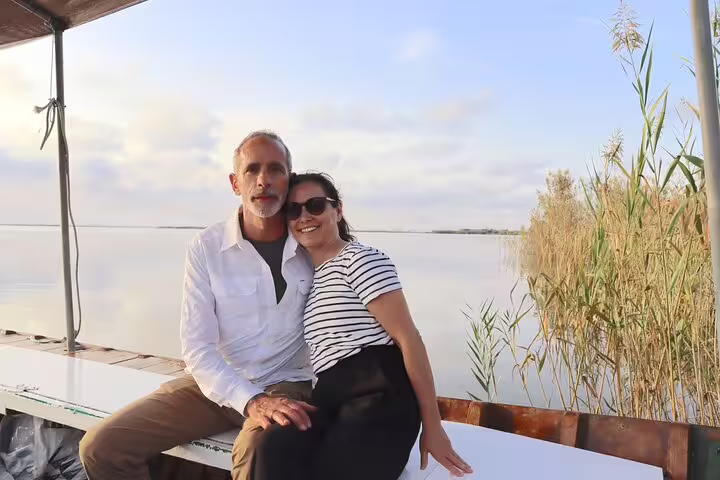 Couple enjoying a serene boat ride on Albufera Lagoon during a private day trip featuring paella and nature trek.