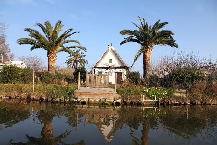 Charming cottage by Albufera lagoon with palm trees, perfect for a private day trip featuring a boat ride and nature trek.