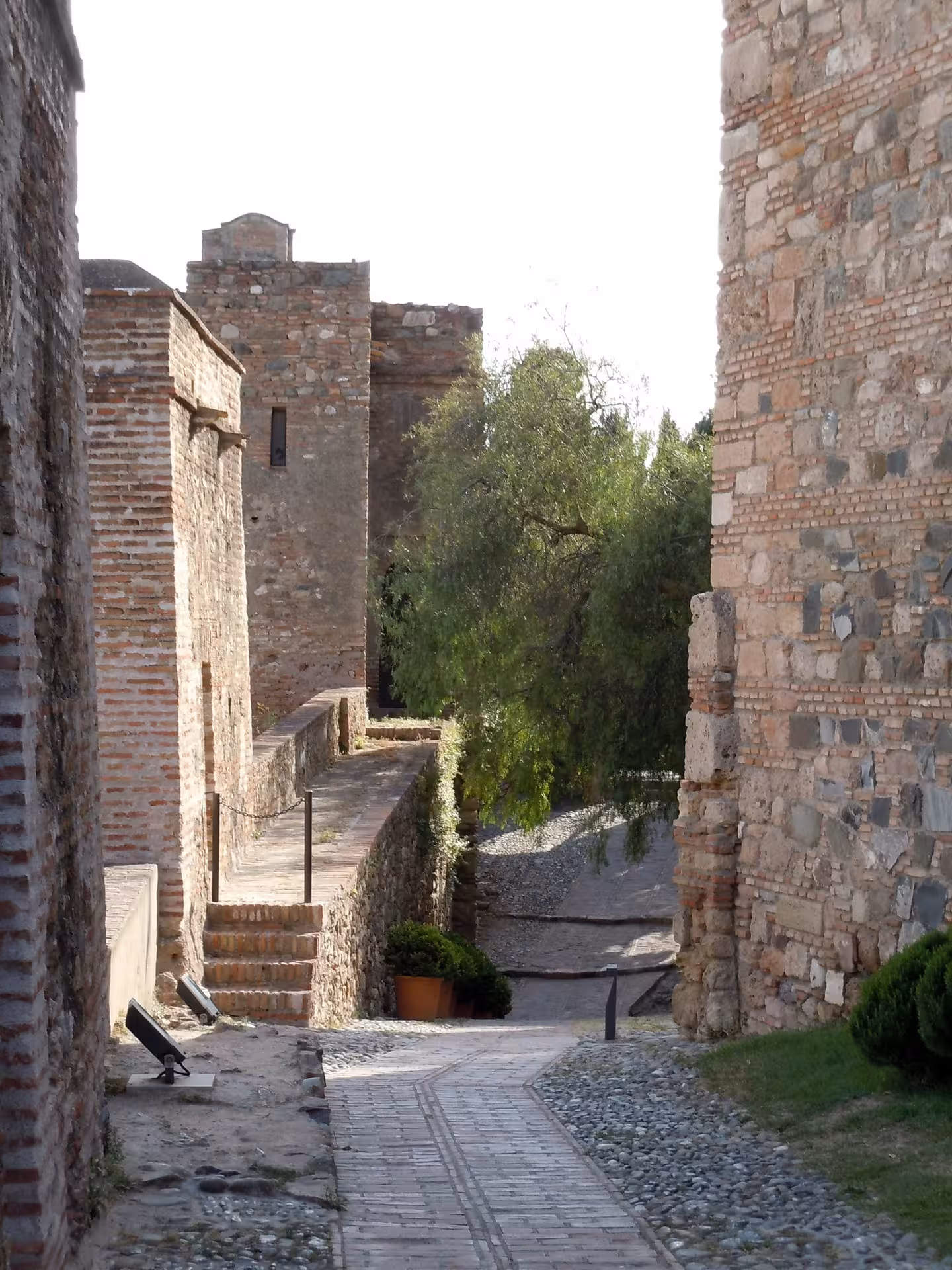Stone passage inside Alcazaba of Malaga with historic walls and gardens, scenic stop on a free Malaga tour