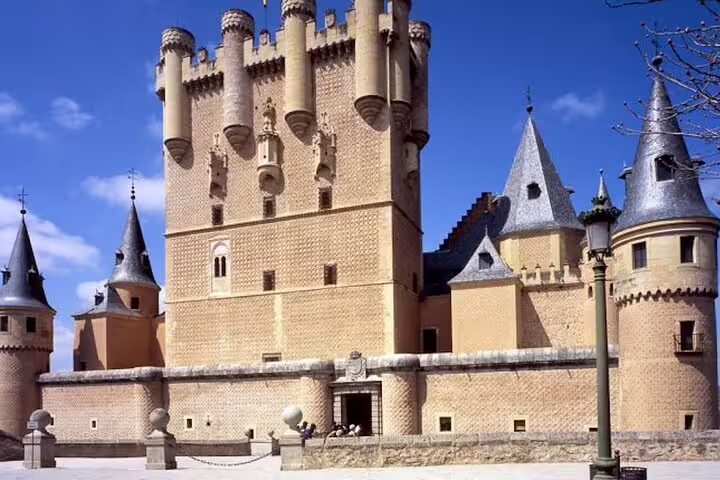 Alcazar of Segovia castle exterior under blue sky, featured on Avila and Segovia private minivan day tour from Madrid