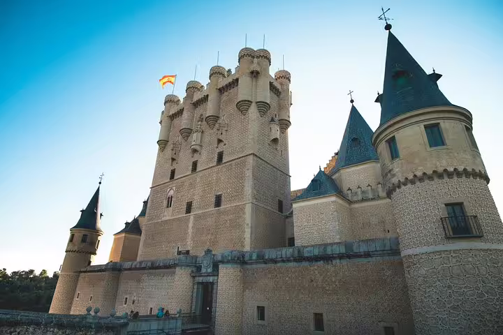 Alcázar of Segovia castle exterior under blue sky, highlight of a private minivan day trip tour from Madrid