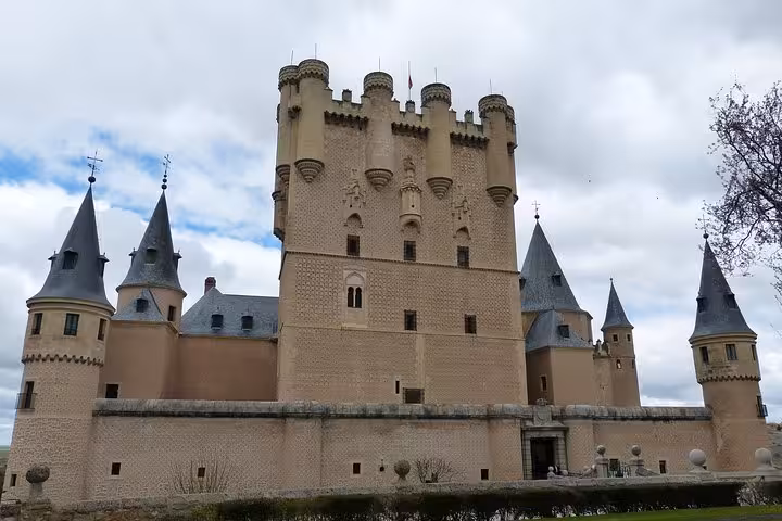 The majestic Alcázar of Segovia under a cloudy sky, featured in the Toledo and Segovia day tour from Madrid.