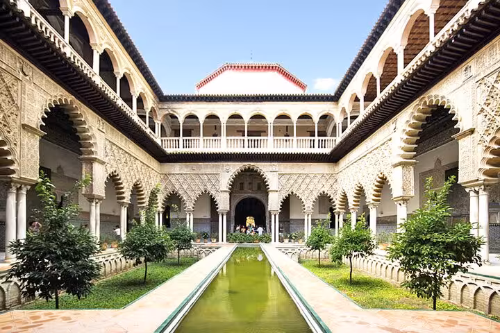 Majestic Alcázar of Seville courtyard with intricate arches and lush gardens, a highlight on the Andalusia and Toledo tour.