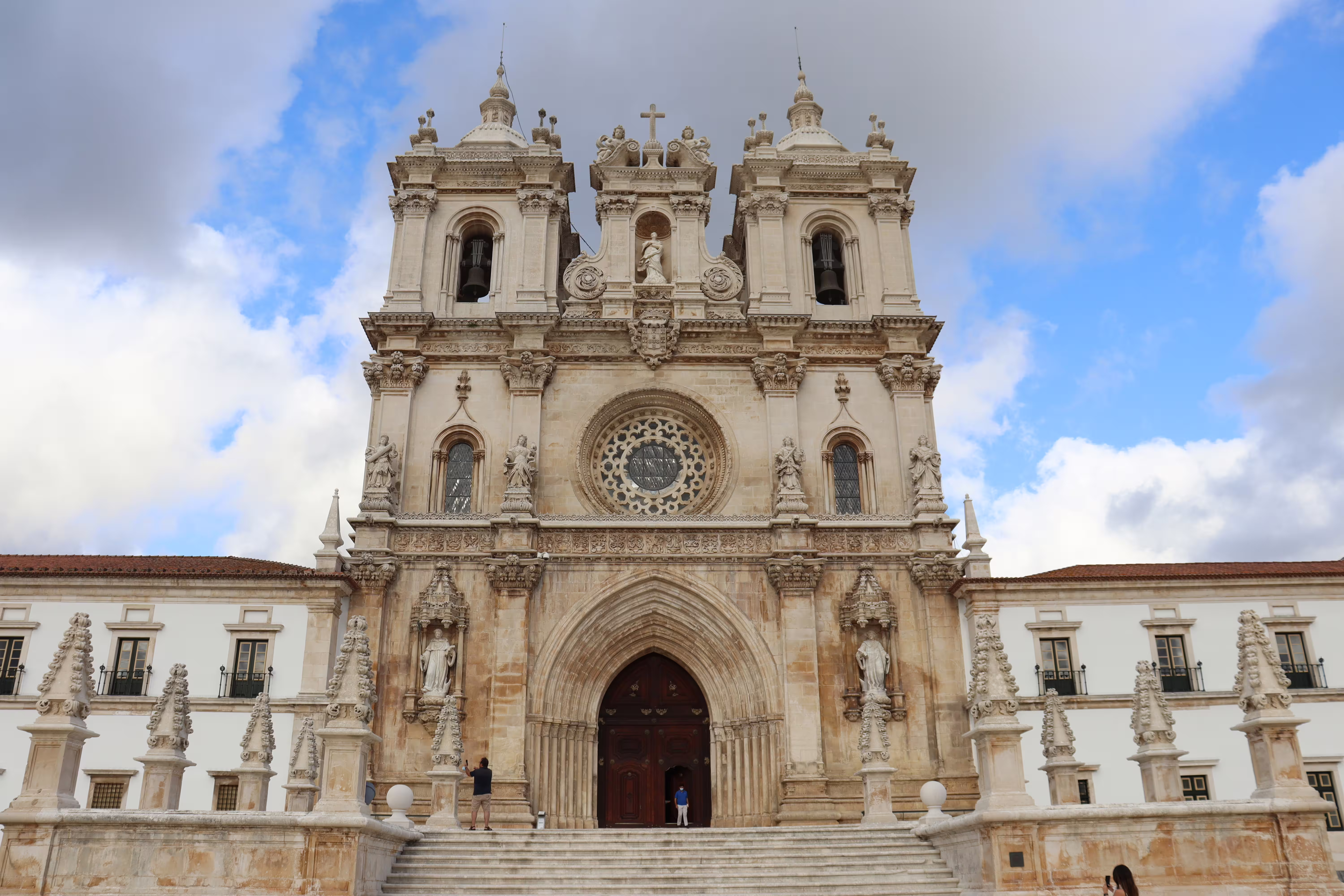 Alcobaça Monastery's stunning façade under a blue sky, featured in a private tour to Nazaré's giant waves and historic sites.