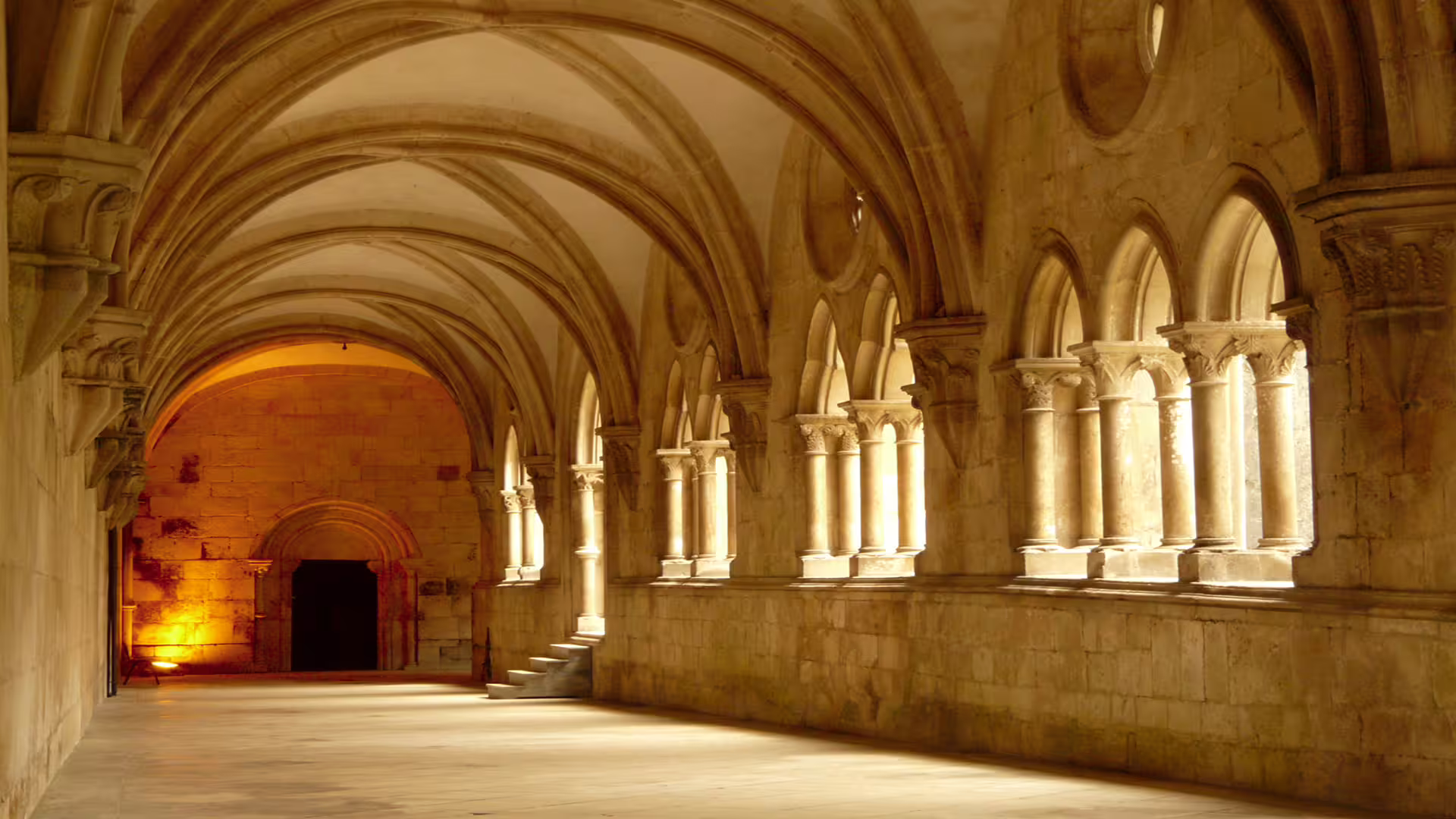 Sunlit Gothic arches inside Alcobaça Monastery, a highlight of the private Nazaré and Alcobaça tour featuring giant waves.