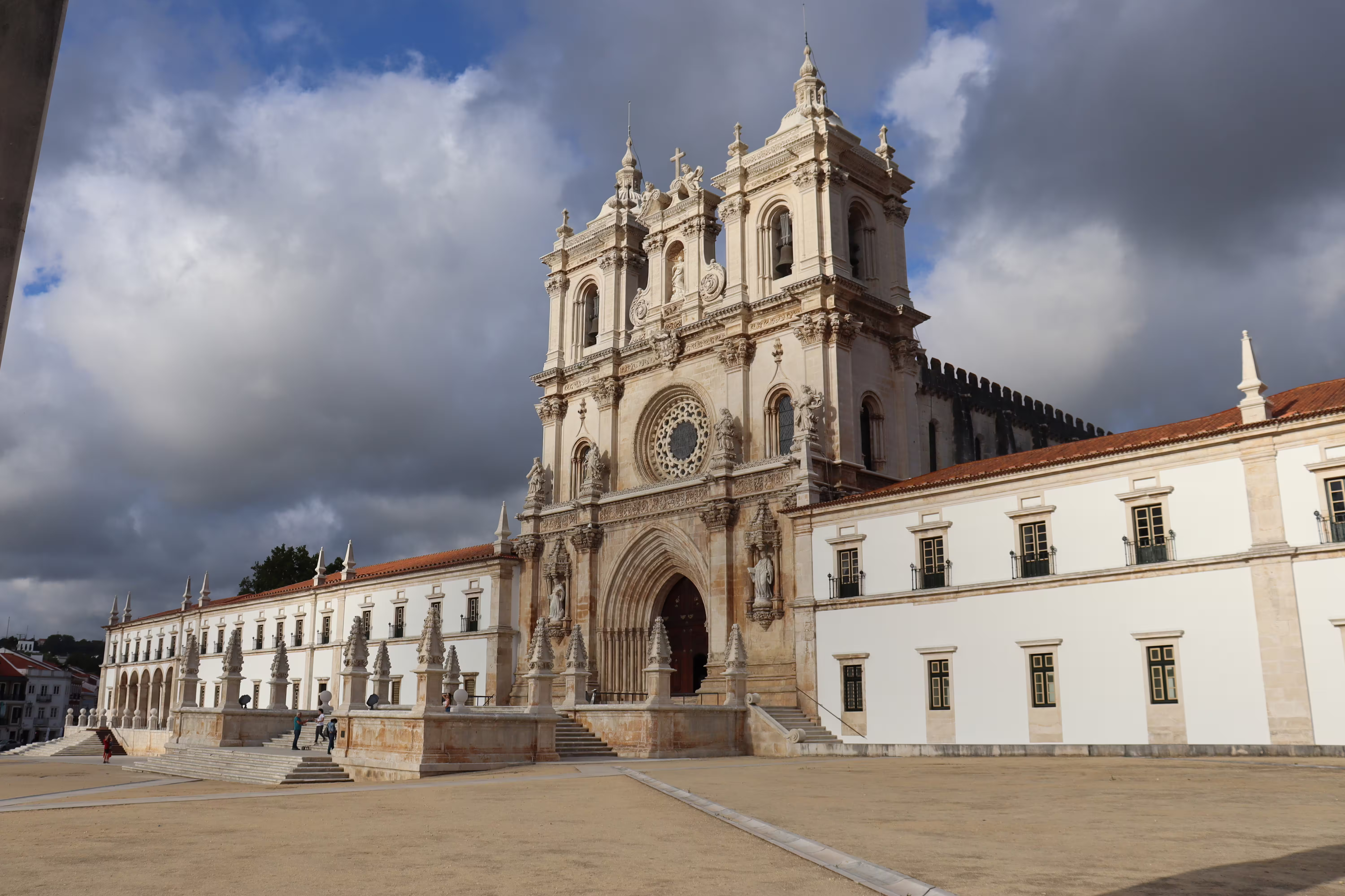 Majestic facade of Alcobaça Monastery under dramatic skies, part of the private tour to Nazaré's giant waves and historic sites.