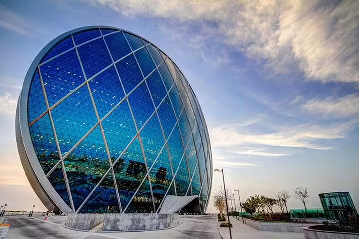 Modern architecture of the Aldar Headquarters building in Abu Dhabi, a key sight on the city tour from Dubai.