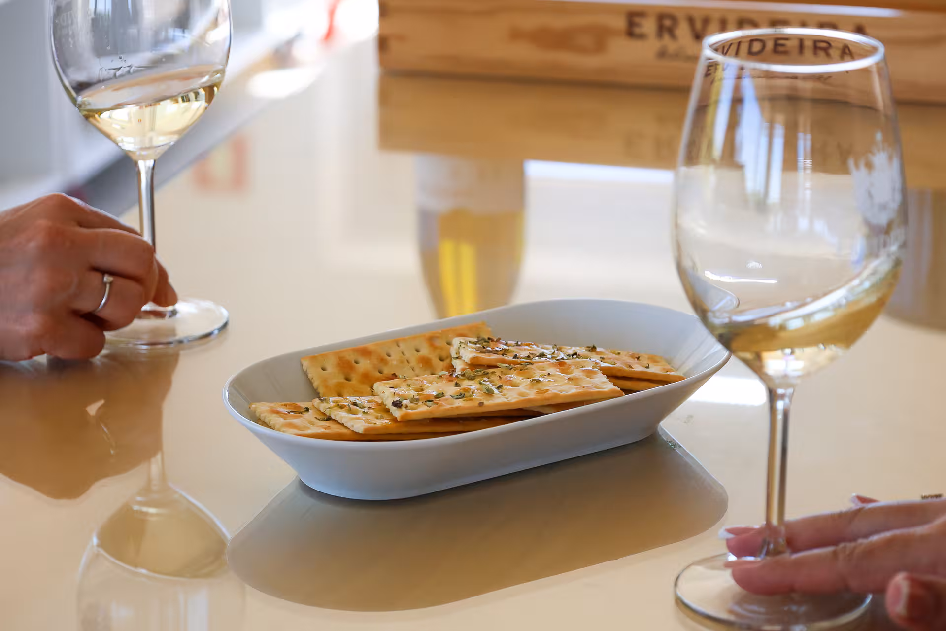 A close-up of white wine and crackers served during a tasting session on the Alentejo wine tour.