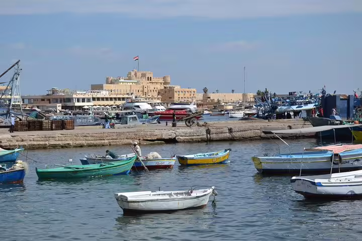 Alexandria harbor with fishing boats and seaside fortress, popular stop on private day tour from Cairo