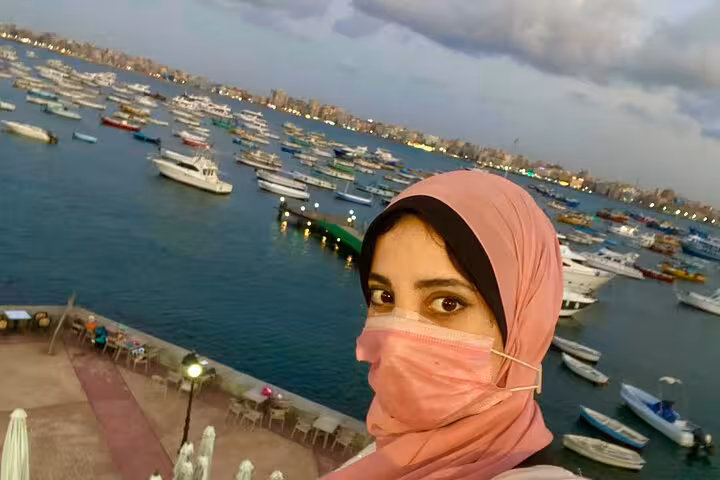 Traveler selfie at Alexandria harbor with yachts at sunset on private tour from Cairo, Egypt day trip