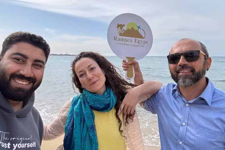 Guests with private guide on Alexandria VIP day tour by the Mediterranean, holding Ramses Egypt sign