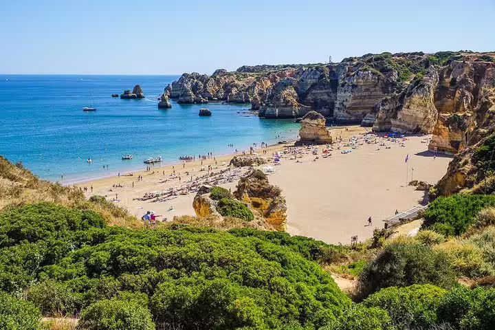 Scenic beach in Algarve with golden sands and dramatic cliffs, ideal for a 2-day private tour from Lisbon.