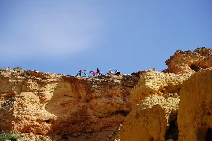 Tourists enjoy breathtaking views from the cliffs during the Algarve full-day private tour from Lisbon with Benagil caves boat trip.