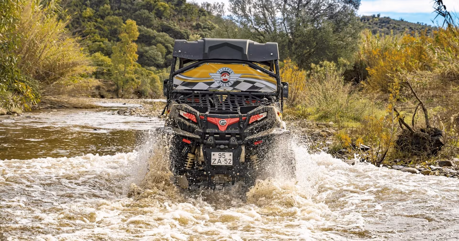 All-terrain buggy splashing through a shallow river on an adventurous full day Algarve off-road buggy safari experience