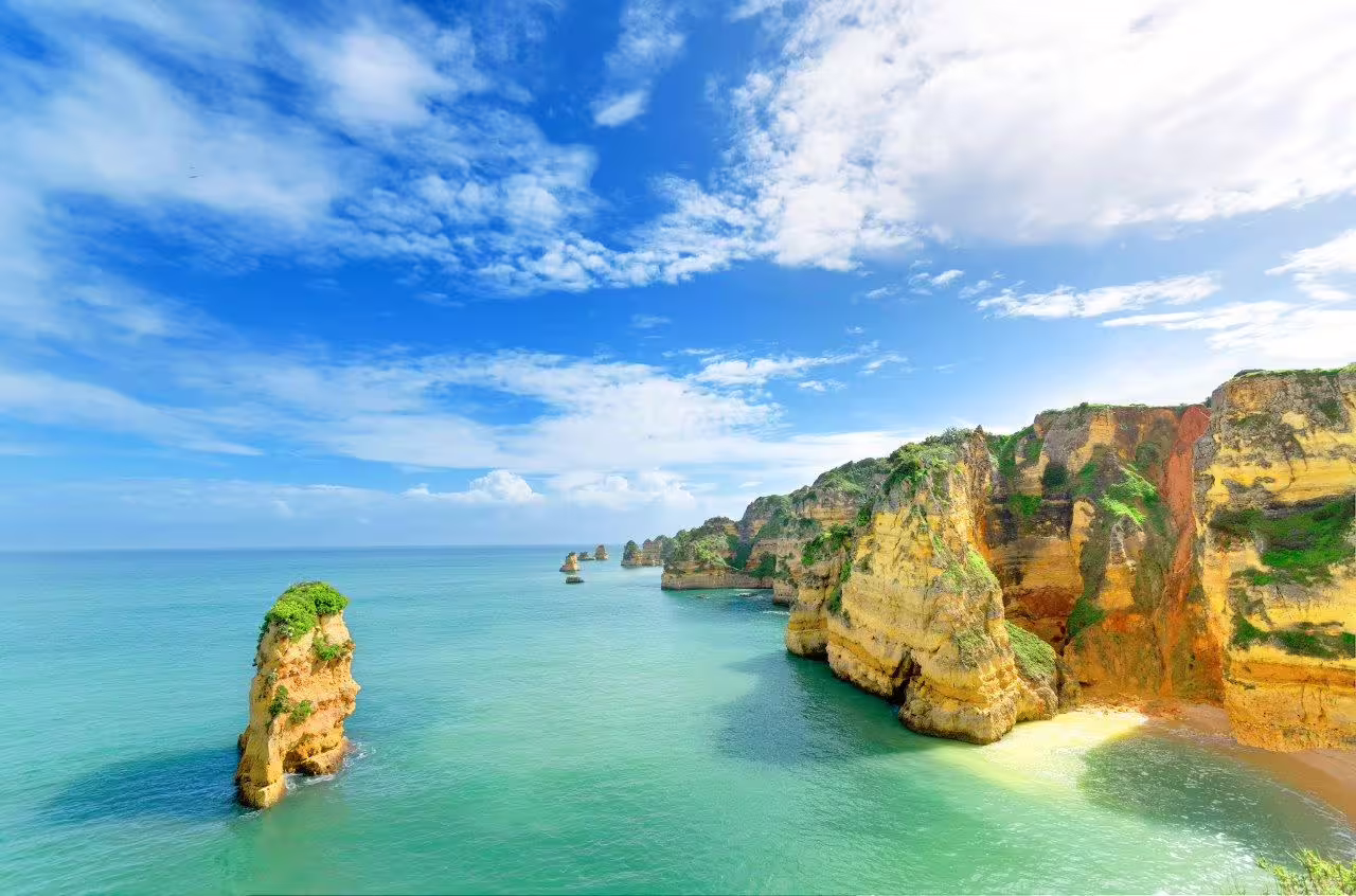 Scenic coastal cliffs and turquoise waters of Algarve, Portugal, ideal for a self-drive exploration of inland paths.