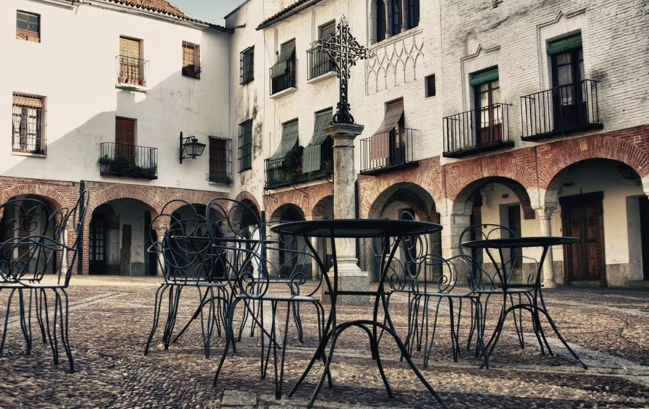 Charming historic square in Algarve with wrought iron tables, perfect for a self-drive tour through Alentejo and Andalucia.