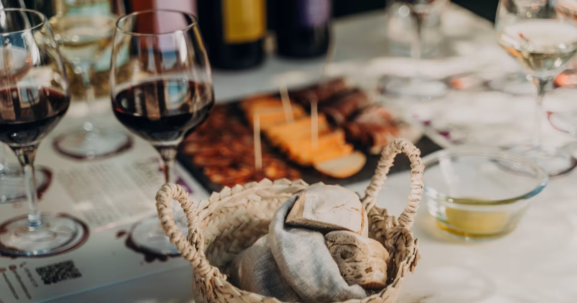 Algarve wine tasting tour with red wine glasses, local tapas charcuterie board, and artisan bread basket