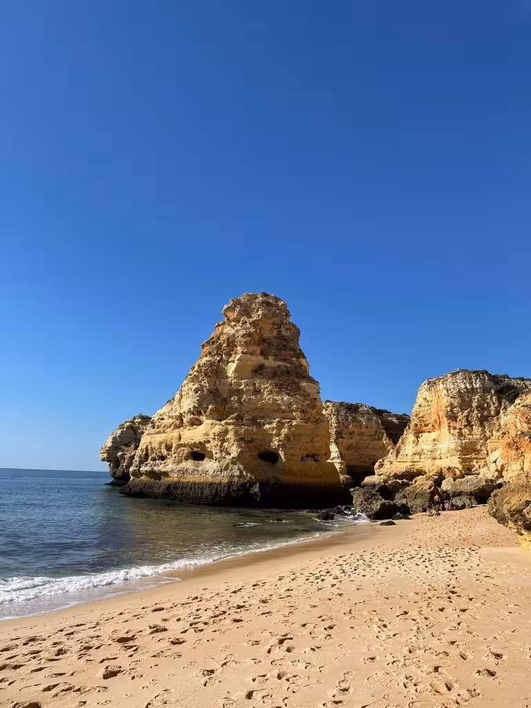 Algarve kayak tour coastline with golden cliffs and sandy beach, calm Atlantic waters and sea caves