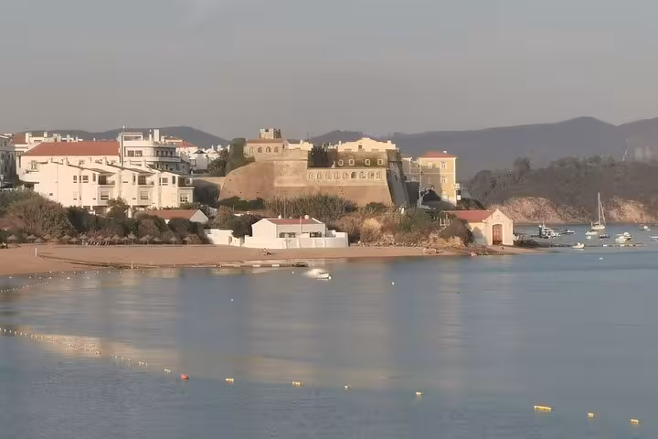 Scenic seaside town and bay stop on Algarve to Lisbon private transfer, waterfront buildings and tranquil water