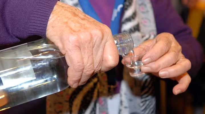 Close-up of local pouring Algarve medronho into a tasting glass during Treasures of the Algarve cultural tour