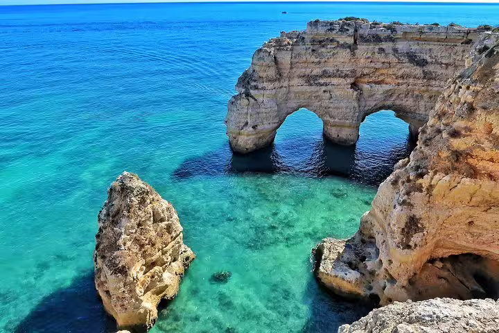 Stunning Algarve coastline with natural arches and clear turquoise waters on a private tour from Lisbon.