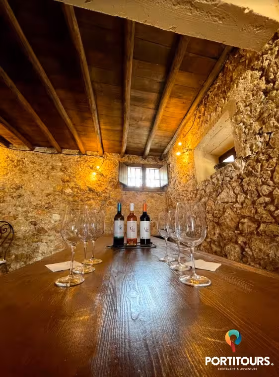 Rustic Algarve wine cellar with tasting table set with glasses and local red, white and rosé bottles for small-group tour