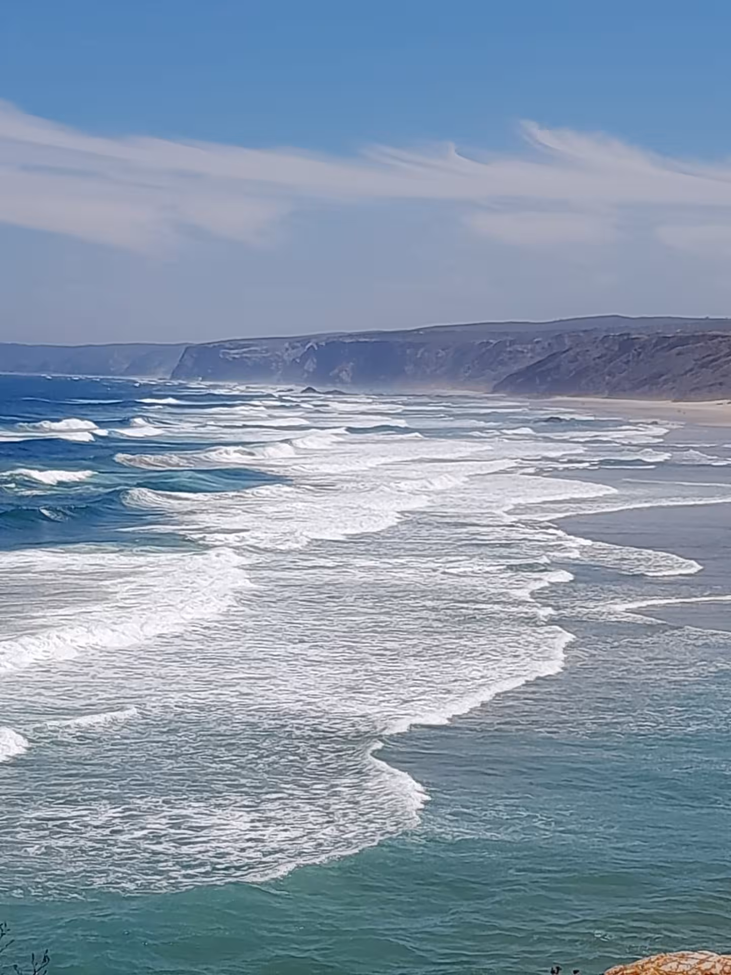 Powerful Atlantic surf breaking along remote cliffs and endless beach on Portugal’s dramatic Algarvian West Coast